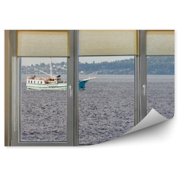 Papier peint Vue d'une fenêtre sur la mer sombre et un navire